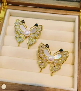 Dettaglio di un'elegante spilla a farfalla con ali di madreperla e pietre di zircone