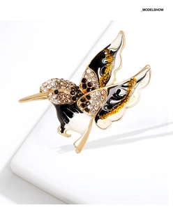 Détail de la broche colibri avec strass et émail noir et blanc sur support doré