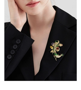 Détail d'une broche paon de luxe avec cristaux colorés sur le revers d'une veste noire