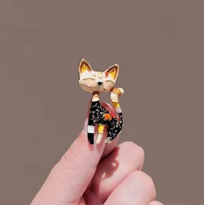 Artistic handmade black cat brooch with colorful enamel finish on a warm background