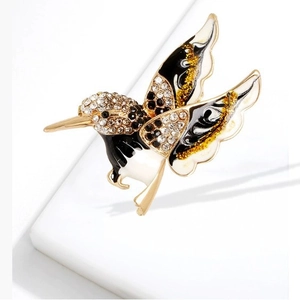 Broche colibri exquise avec strass et ailes en émail sur un support blanc