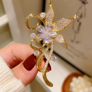 Elegant gold flower brooch with sparkling rhinestones in a vintage palace style