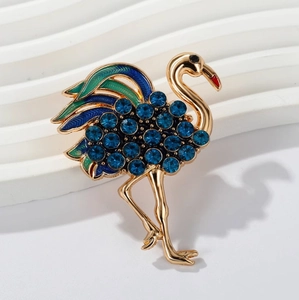 Broche flamant rose dorée élégante avec cristaux bleus et émail vert coloré