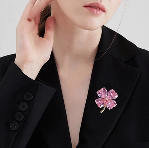 Élégante broche trèfle à quatre feuilles avec cristaux roses sur un blazer noir chic