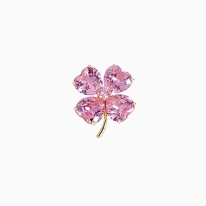 Broche trèfle dorée exquise avec quatre pierres roses en forme de cœur sur fond blanc