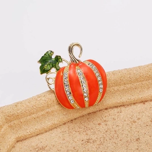 Détail macro d'une broche citrouille d'Halloween avec émail orange et strass brillants