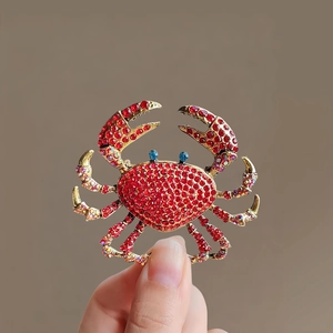 Vue détaillée de la broche crabe en alliage doré ornée de strass rouges et bleus brillants