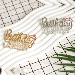 Golden and silver Birthday Queen brooches with pink crown and rhinestones on white tray