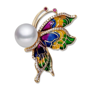 Détail d'une broche papillon avec ailes en émail coloré, perle et placage à l'or