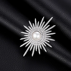 Spilla a forma di fiore di sole con perla centrale e cristalli su pelle nera elegante