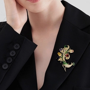 Broche paon luxueuse avec pierres colorées sur le revers d'un blazer noir chic