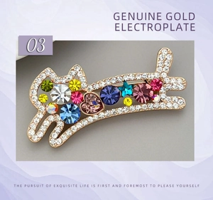 Détail de la broche chat avec cristaux colorés et strass étincelants sur placage or rose