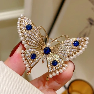 Close-up of pearl and rhinestone butterfly brooch with deep blue sapphire accents