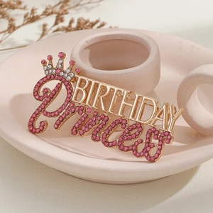 Vue détaillée de la broche dorée Birthday Princess avec strass roses et couronne