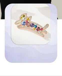 Détail d'une broche animal en or rose avec zircons colorés en forme de cœur et étoile