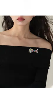 Détail d'une broche chat en cristal coloré sur un vêtement noir avec pierres vives