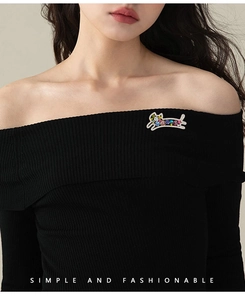 Vue détaillée d'une broche chat en cristal coloré sur un haut en maille noir élégant
