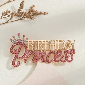 Vue macro de la broche Birthday Princess avec strass roses et une couronne dorée