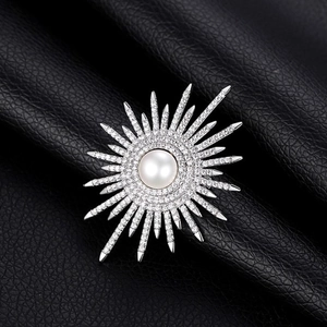 Elegante spilla a girasole con strass scintillanti e perla bianca su sfondo nero