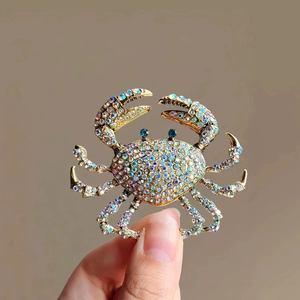 Broche crabe dorée ornée de strass AB irisés et de gemmes bleues pour femme
