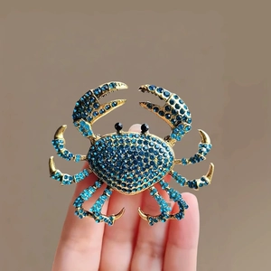 Broche crabe dorée élégante avec strass bleus et détails en cristal étincelants