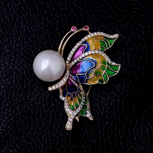 Vue détaillée de la broche papillon avec perle, émail coloré et diamants incrustés