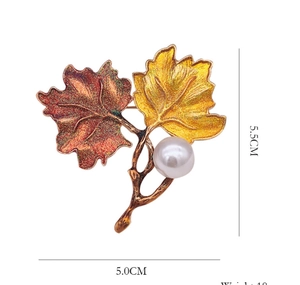 Detail view of enamel maple leaf brooch with pearl showing 5.5cm by 5.0cm dimensions