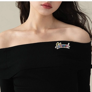 Broche chat chic avec cristaux colorés portée sur un haut en maille noire