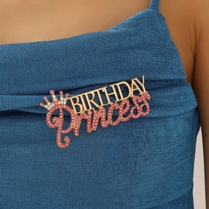 Broche dorée Birthday Princess avec strass roses et couronne sur tricot bleu