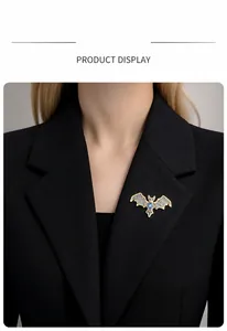 Macro detail of bat-shaped brooch with blue crystals on a black suit jacket lapel
