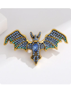Makro-Detail der gotischen Fledermaus-Brosche mit blauen Strasssteinen auf Weiß