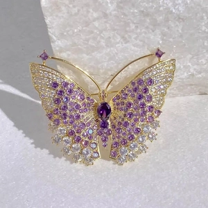 Macro detail van elegante vlinderbroche met paarse kristallen en goudkleurig filigraan