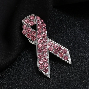Makroaufnahme einer rosa Schleifen-Brosche aus Silberlegierung mit Strass auf schwarzem Grund