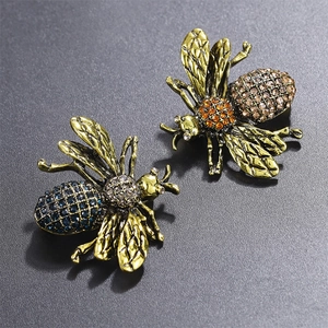 Close-up detail of vintage style bee brooches with blue and champagne rhinestones