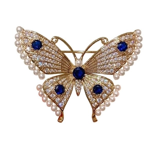 Elegant gold butterfly brooch with blue rhinestones, pearls and sparkling white zircon