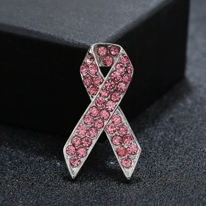 Makroaufnahme der rosa Bandschleife-Brosche mit Strasssteinen auf schwarzem Hintergrund