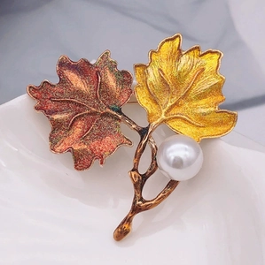 Vintage enamel maple leaf brooch with red and yellow leaves and a round white pearl