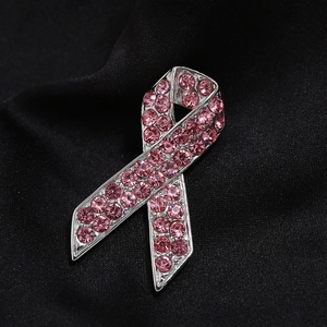 Detaillierte Makroansicht der rosa Strass-Schleifenbrosche auf schwarzem Seidenstoff