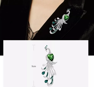 Detailed macro view of 9cm silver peacock brooch with green gemstones on black velvet suit