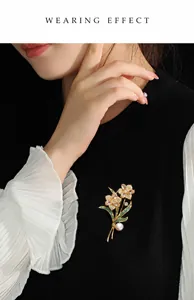 Detail view of champagne crystal flower brooch with pearl accent on a suit lapel