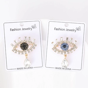 Macro shot of Evil Eye brooches featuring sparkling blue rhinestones and crystal teardrops