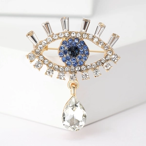 Detailed macro of Evil Eye brooch with blue crystals and a teardrop pendant