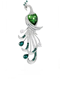Detail of silver peacock brooch with heart emerald gemstone and green zircons