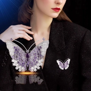 Elegante vlinderbroche met paarse en witte kristallen op zilveren metalen basis