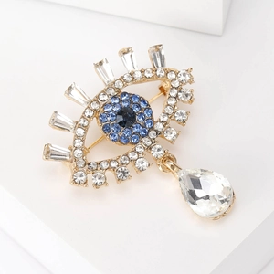 Close-up of luxury evil eye brooch with blue crystals and sparkling teardrop zircon