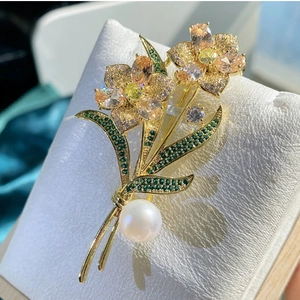 Elegant gold rose flower brooch with sparkling rhinestones and a large white pearl accent