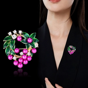 Détail de la broche baie avec perles mauves, feuilles émaillées vertes et strass blancs