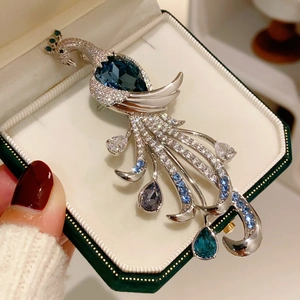 Detail of luxury peacock brooch with blue gemstones and diamonds on jewelry box