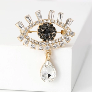 Macro view of luxurious evil eye brooch with crystals and teardrop gemstone pendant