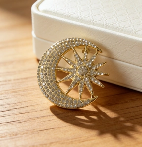 Macro detail of gold moon and star brooch with sparkling rhinestones on jewelry box